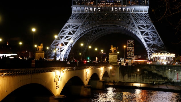 Les mots « Merci Johnny » apparaissent sur la tour Eiffel illuminée. Les mots « Merci Johnny » apparaissent sur la tour Eiffel illuminée.