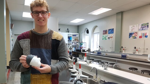 Jonathan Lévesque pose dans un laboratoire avec son prototype de coeur artificiel