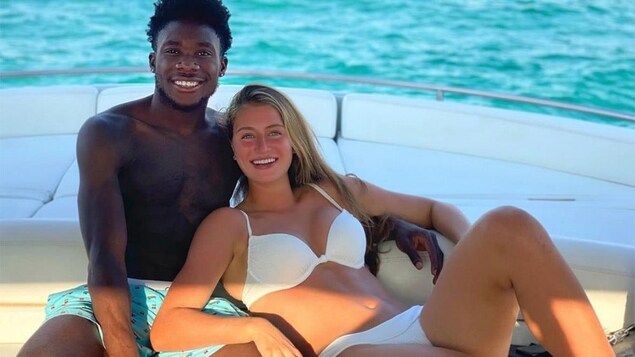 Jordyn Huitema et Alfonso Davies enlacés sur un bateau.