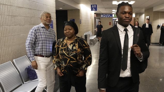 Joseph-Christopher Luamba, right, arrives with his mother and father for his court challenge on May 30, 2022 in Montreal. Luamba sued the government over alleged police racial profiling