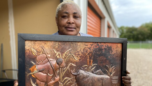 L'artiste Joséphine Tambwe Feza Kabibi tient une de ses oeuvres en cuivre martelé.