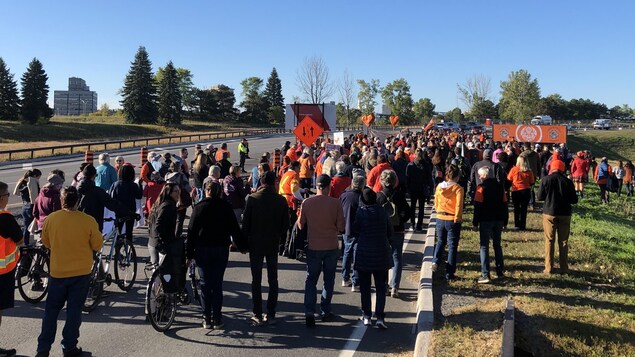 Près de 200 personnes marchent sur la promenade à Ottawa.