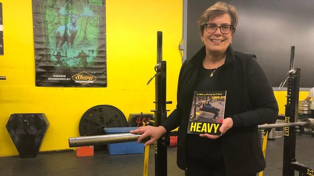 Une septuagénaire debout devant un appareil de gymnase. Une septuagénaire debout devant un appareil de gymnase.