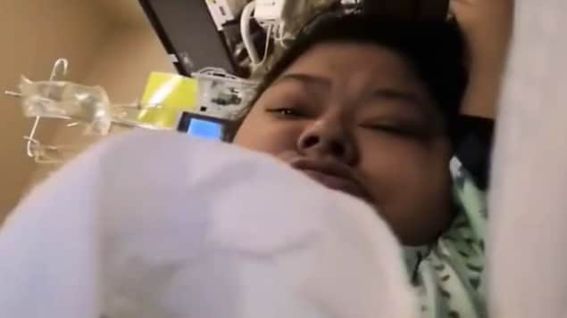 Una mujer indígena en una cama de hospital.