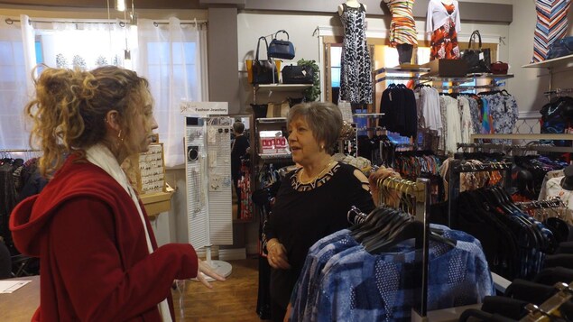 La mère de la propriétaire aidant un client dans le magasin. La mère de la propriétaire aidant un client dans le magasin.