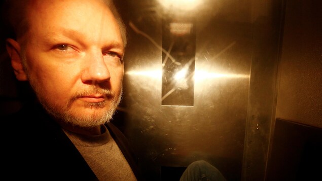 M. Assange aveuglé par la lumière, dans ce qui semble être un ascenseur.