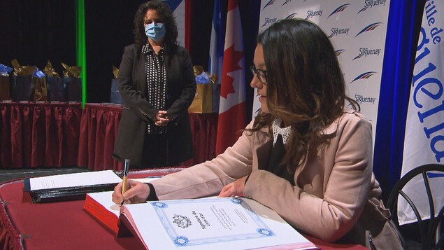 Julie Dufour signe un document officiel.