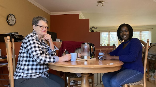 Deux femmes assises l'une en face de l'autre sont en train de boire de la tisane.