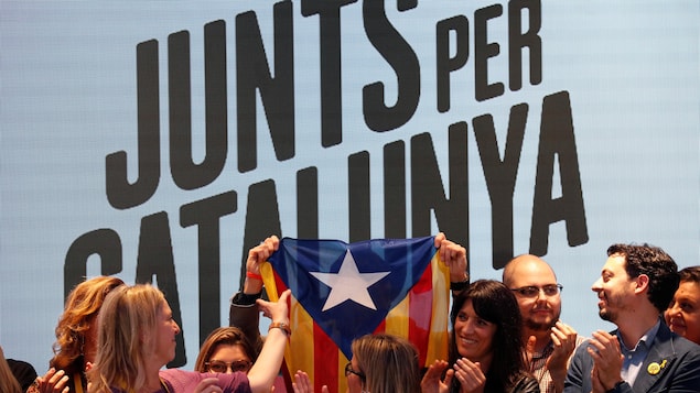 Des hommes et des femmes brandissant le drapeau séparatiste catalan.
