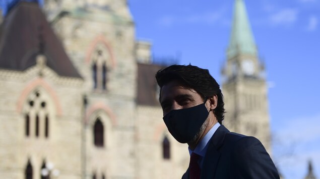 Justin Trudeau, masqué, près du parlement.