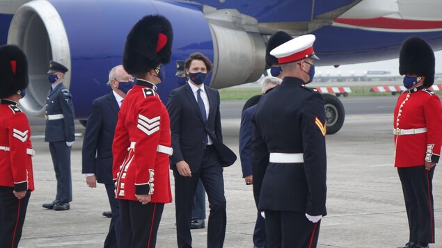 Justin Trudeau marchant entre des rangées de militaires britanniques.