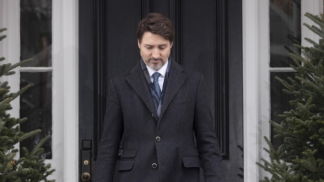 Justin Trudeau sort d'une maison.