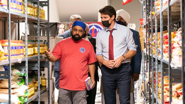 Nakikipag-usap si Justin Trudeau sa isang lalaki sa loob ng food bank.