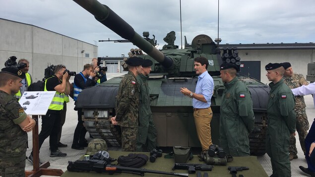 Justin Trudeau parle à des militaires devant un char d'assaut. Justin Trudeau parle à des militaires devant un char d'assaut.