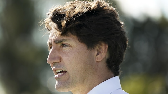 Justin Trudeau de profil lors d'un point de presse à l'extérieur.