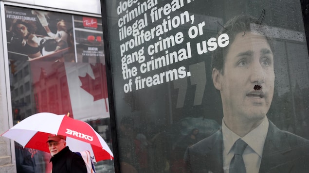 Une pancarte vandalisée de Justin Trudeau avec des cornes et une moustache en brosse à dents ajoutées au marqueur. 