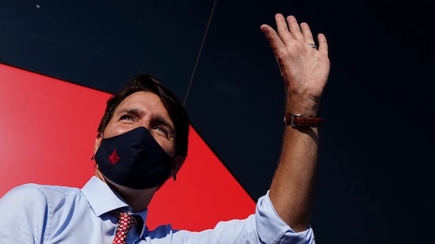 Portrait de Justin Trudeau dui salue de la main.