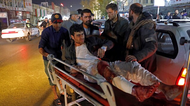 Des Afghans transportent un blessé à l'hôpital après un attentat suicide à Kaboul. Des Afghans transportent un blessé à l'hôpital après un attentat suicide à Kaboul.