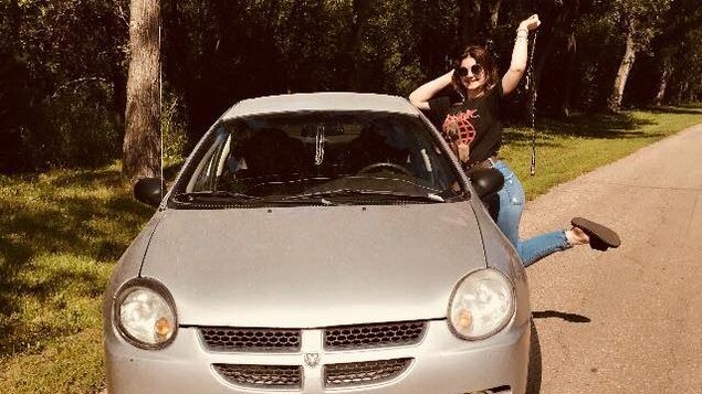 Kailynn Bursic-Panchuk pose à côté de sa voiture sur une route rurale ensoleillée. Kailynn Bursic-Panchuk pose à côté de sa voiture sur une route rurale ensoleillée.