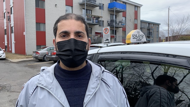 Un chauffeur de taxi à côté de son véhicule