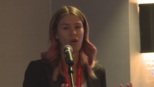 Kaitlin Bick parle à un micro.
