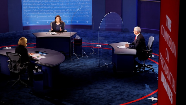 Les deux candidats sont assis devant la modératrice.