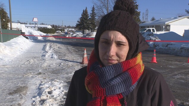 Karine Jolicoeur, une dame habillée en tenue hivernale, lors d'une entrevue devant un ruban de police qui ferme une rue. Karine Jolicoeur, une dame habillée en tenue hivernale, lors d'une entrevue devant un ruban de police qui ferme une rue.