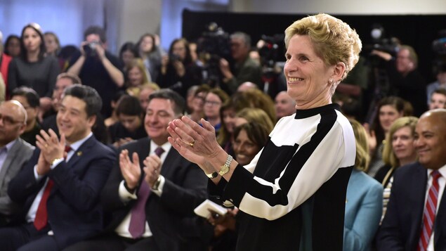 Kathleen Wynne applaudit devant une salle comble. Kathleen Wynne applaudit devant une salle comble.