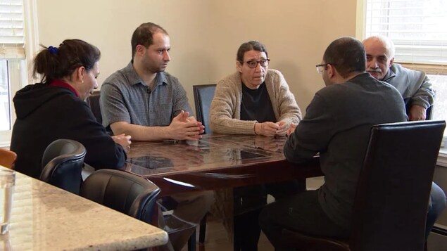La photo de la famille Zarafshanpour, assise autour d'une table.