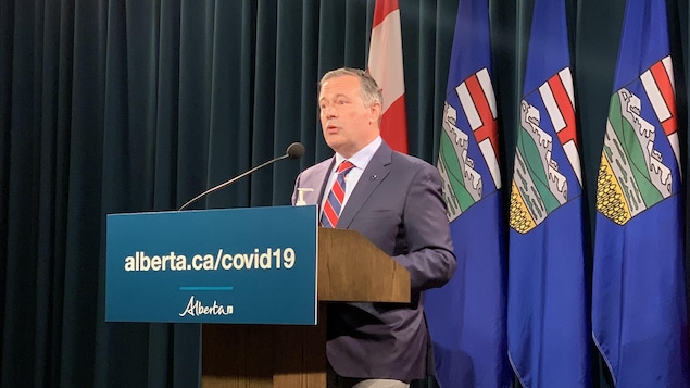 Jason Kenney, en conférence de presse devant des drapeaux albertains, le vendredi 3 septembre 2021.