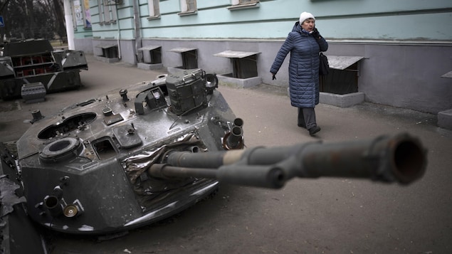 Une femme passe devant un char russe détruit exposé dans une rue du centre de Kiev, en Ukraine.
