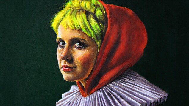 La jeune femme porte une capuche rouge et une collerette blanche.
