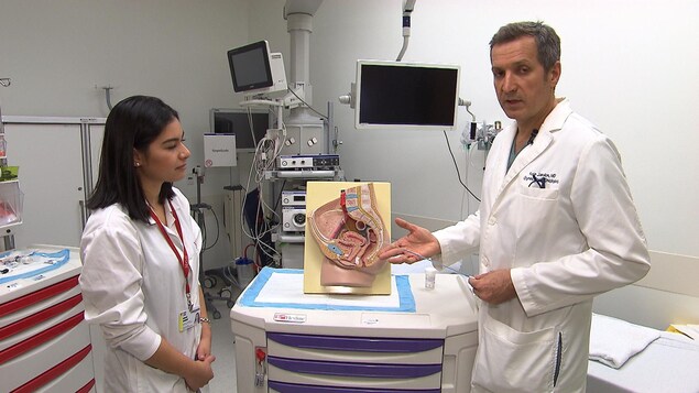 Le Dr Kardon pointe un schéma reproduisant l'intérieur de l'appareil reproducteur féminin.