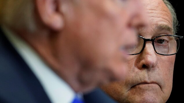 Larry Kudlow avec, devant lui, le visage flou de Donald Trump.