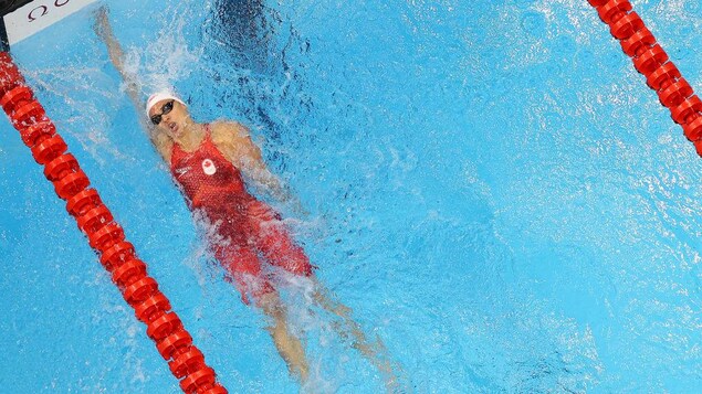 Kylie Masse étire le bras pour toucher le mur de la piscine, au bout du corridor.