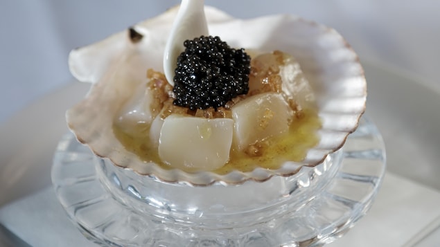 Du caviar servi sur une coquille Saint-Jacques.