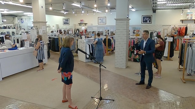 La copropriétaire du magasin Laliberté, Lucie Morisset, en entrevue avec Bruno Savard, à l'intérieur du magasin avec des clients autour.