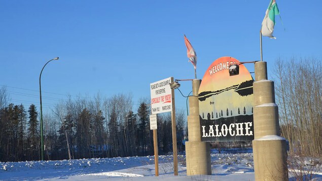 Un panneau indique la limite du village de La Loche sous un ciel découvert.