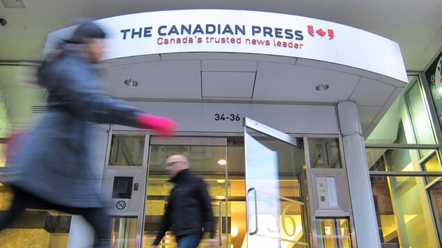 Une personne sort des bureaux de La Presse canadienne à Toronto.