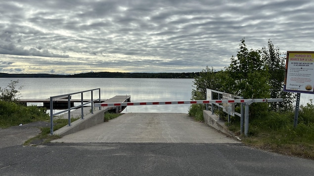 Une barrière devant un quai sur un lac.