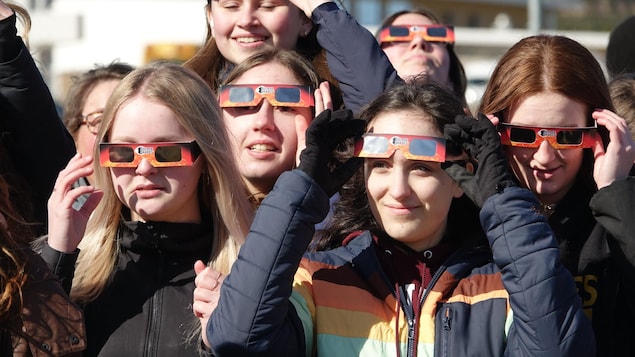 Un groupe de jeunes filles portent des lunettes de protection pour regarder l'éclipse solaire du 8 avril 2024. 