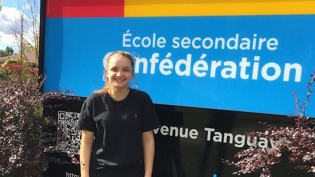 Photo de Laveena devant le panneau de l'école Photo de Laveena devant le panneau de l'école