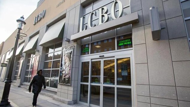 Une succursale de la LCBO avec un homme qui passe devant.