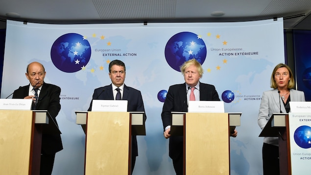 Quatre diplomates derrière des lutrins, en conférence de presse. Quatre diplomates derrière des lutrins, en conférence de presse.