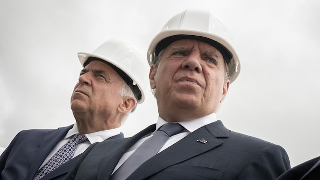Le premier ministre du Québec François Legault et le ministre de l'Économie Pierre Fitzgibbon avec des casques de chantier.