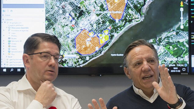 Le premier ministre Francois Legault et le PDG d'Hydro-Québec Eric Martel devant une carte du Québec indiquant les pannes.
