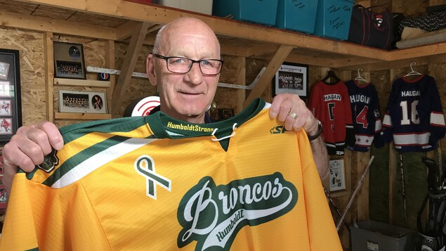 Darcy Haugan tient dans ses mains un chandail de hockey des Broncos de Humboldt. Darcy Haugan tient dans ses mains un chandail de hockey des Broncos de Humboldt.