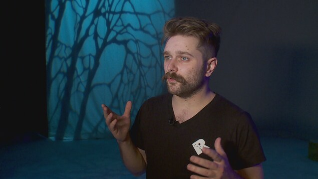 Un homme se tient devant un décor de théâtre. Un homme se tient devant un décor de théâtre.