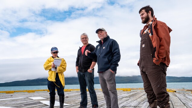 Quatre membres de l'Association pour la préservation du phare d'Eldred Rock se tiennent sur le ponton du phare.