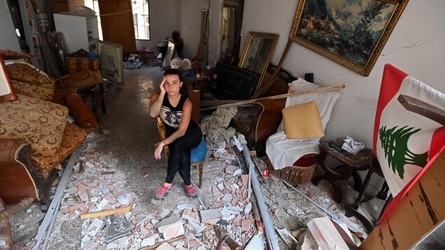 Une femme est assise au milieu des décombres de sa maison endommagée dans la capitale libanaise, Beyrouth, le 6 août 2020, deux jours après qu'une explosion massive ait secoué la ville.